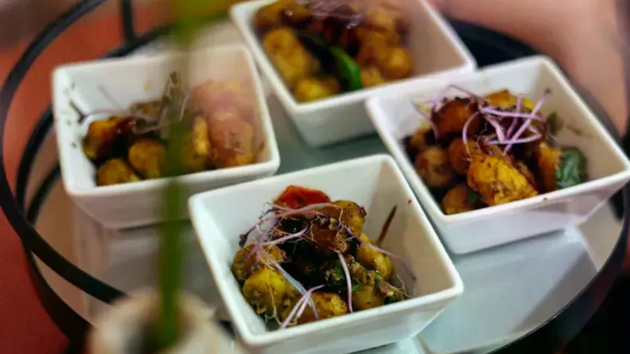 Four bowls of seasoned potatoes on a tray.