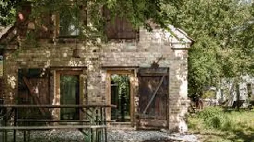Rustic brick house in a leafy yard.