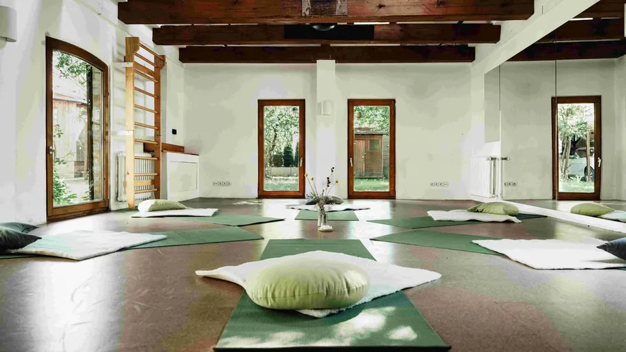 Yoga mats and cushions arranged in bright studio.