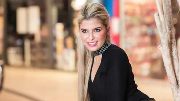 Woman smiling, shopping mall background.