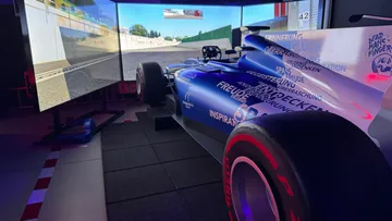 Rennwagen-Simulator mit projiziertem Streckenbild.