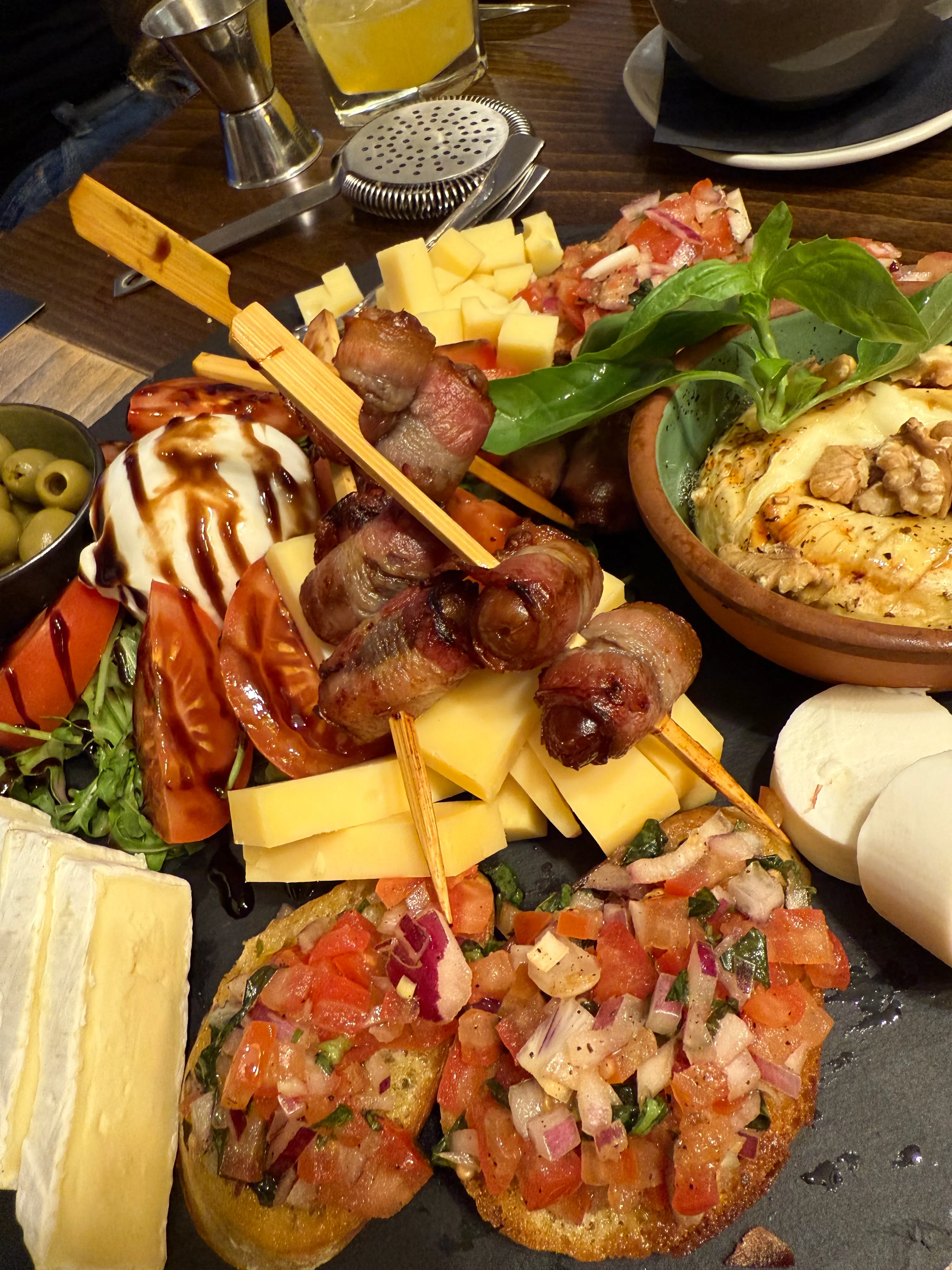 Käseplatte mit Fleisch, Gemüse und Dips.