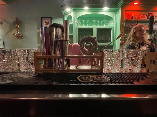 Bar counter with glasses and bartender.