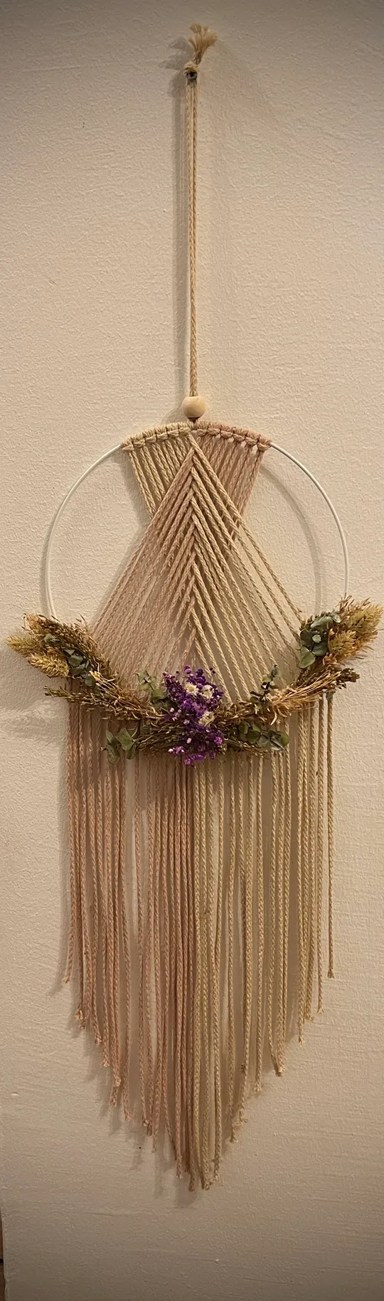 Makramee-Wandbehang mit Blumendekoration.