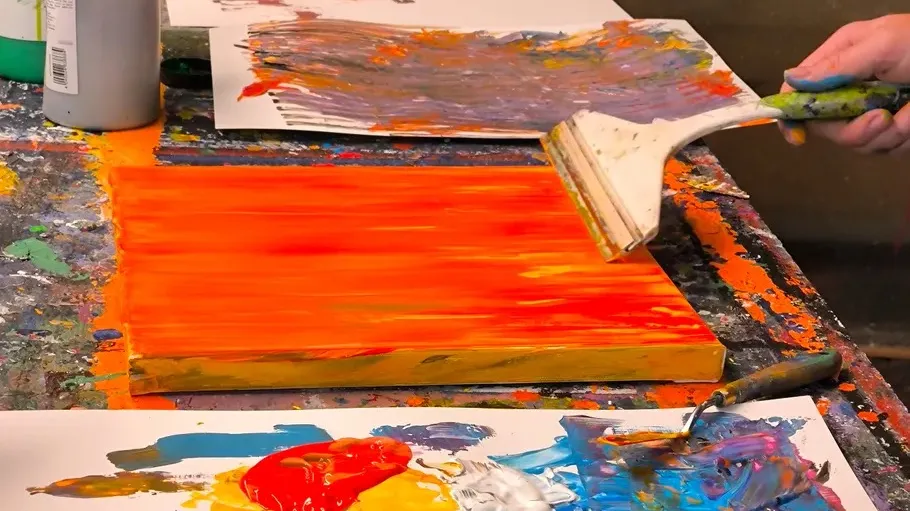 Person painting abstract art on colorful canvas.
