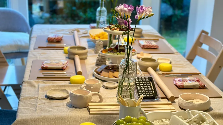 Dining table set with snacks and flowers.