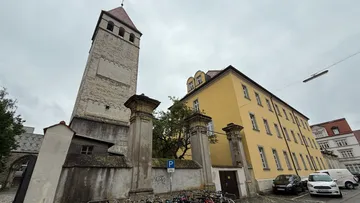 Tower and yellow building in urban setting.