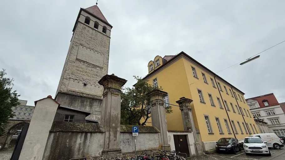 Tower and yellow building in urban setting.