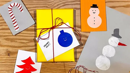 Geschenk mit festlichen Karten auf Holztisch.