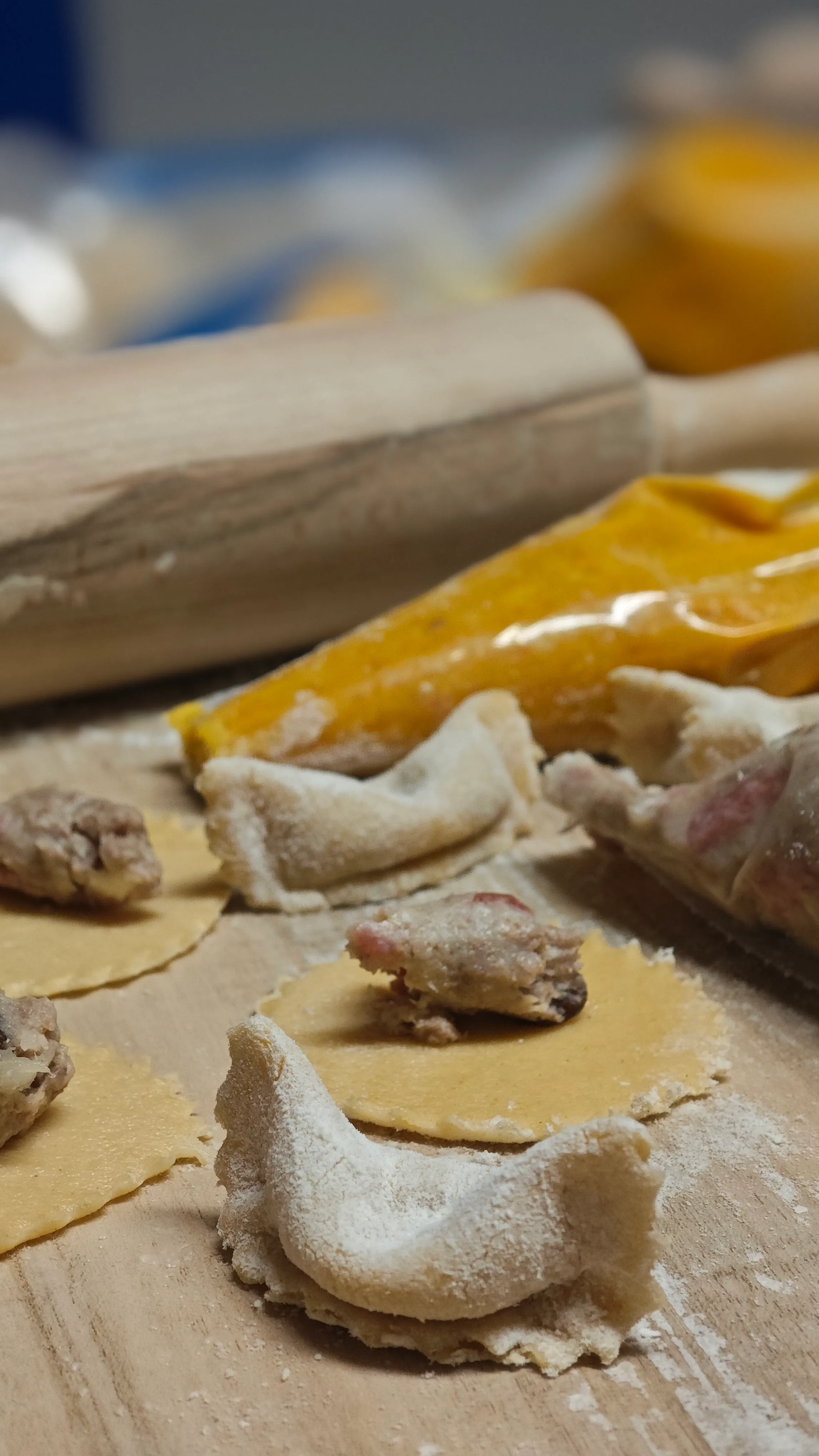 Ungekochte Ravioli mit Füllung auf Holztisch.