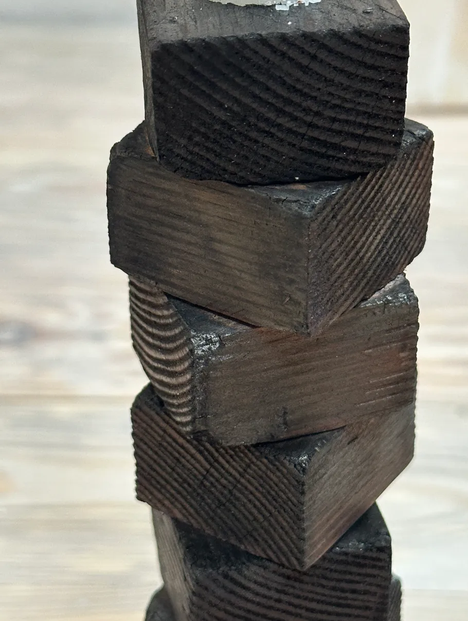 Stacked dark wooden blocks, indoor setting.