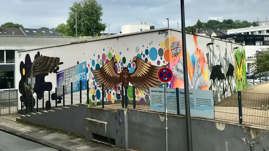 Mural with colorful wings on building.