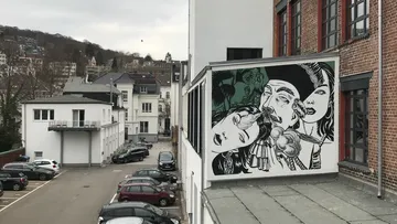 Gebäudemalerei in städtischem Parkplatzbereich.