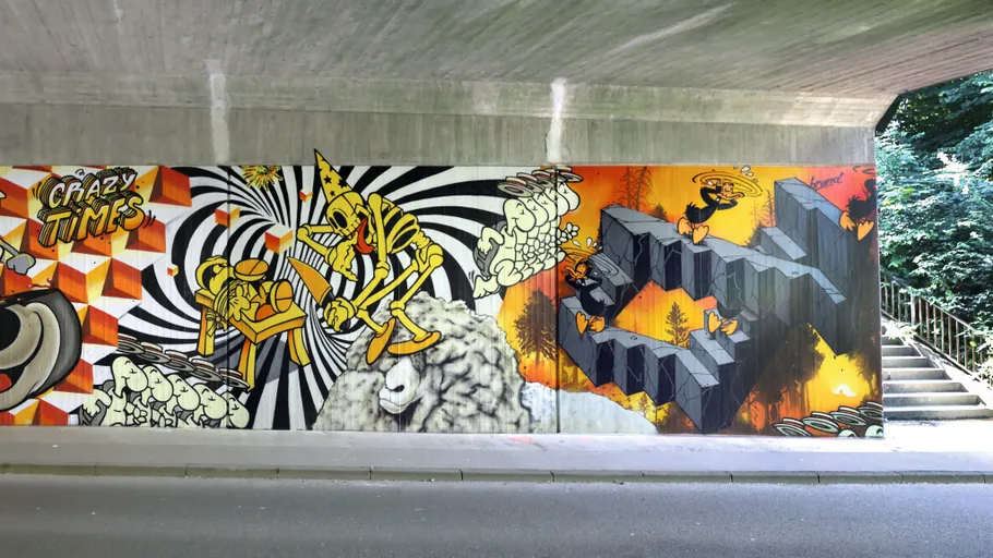 Colorful street art mural under a bridge.