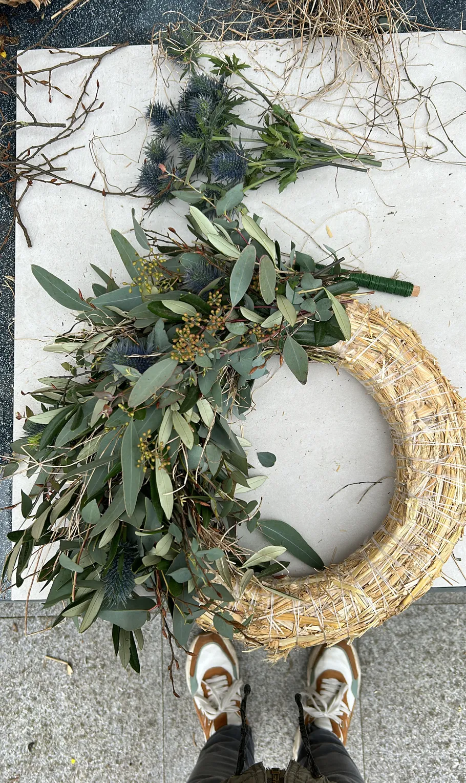 Partially decorated straw wreath on the ground.