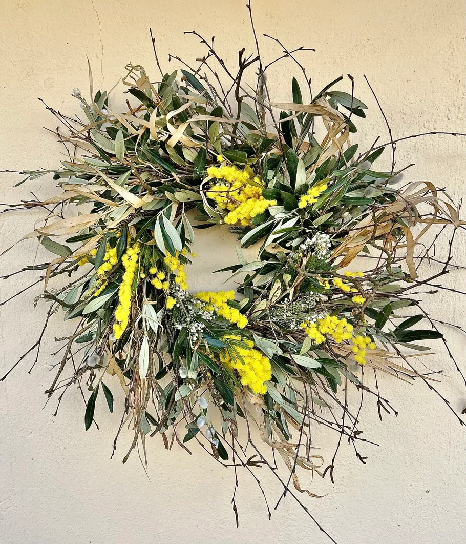 Floral wreath with yellow flowers on wall.