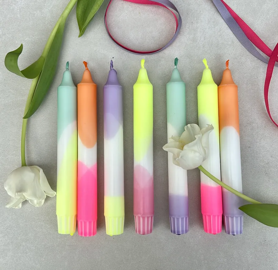 Colorful candles arranged with tulips and ribbons.