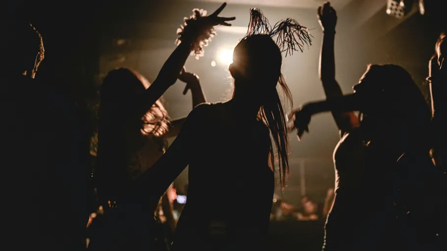 Silhouettierte Menschen tanzen im Club.