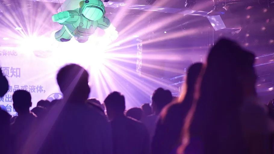Menschen im Club mit Astronautenprojektion.