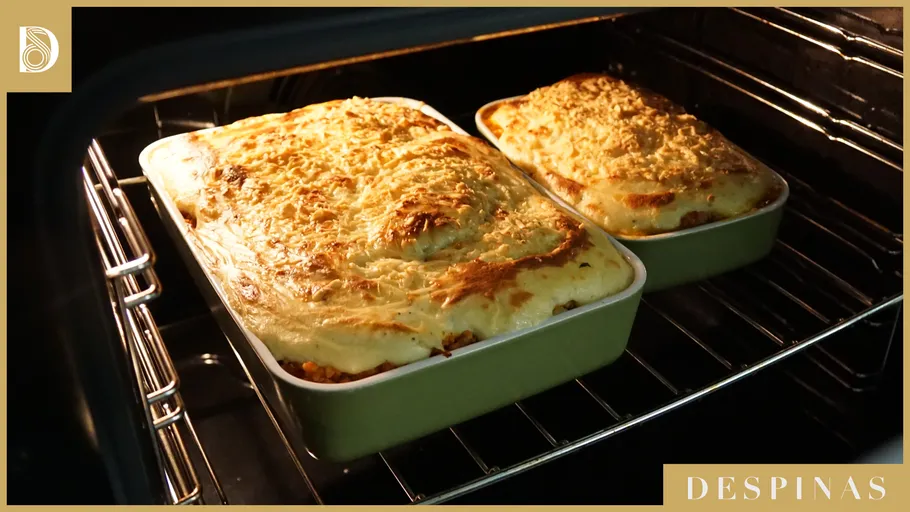 Two dishes of lasagna baking in oven.