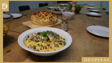 Tisch mit Nudelschüssel und Brot im Vordergrund.
