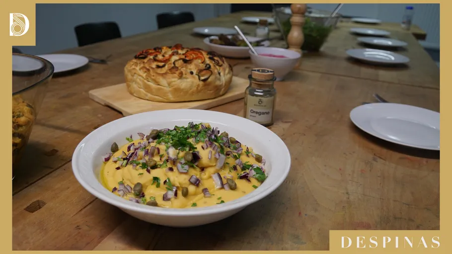 Tisch mit Nudelschüssel und Brot im Vordergrund.