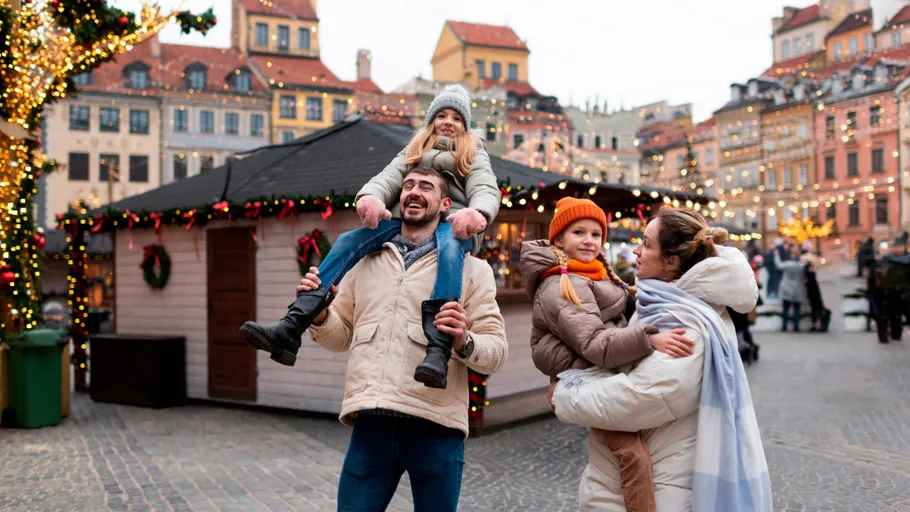 Familie genießt Weihnachtsmarkt, lächelt, Winterkleidung.