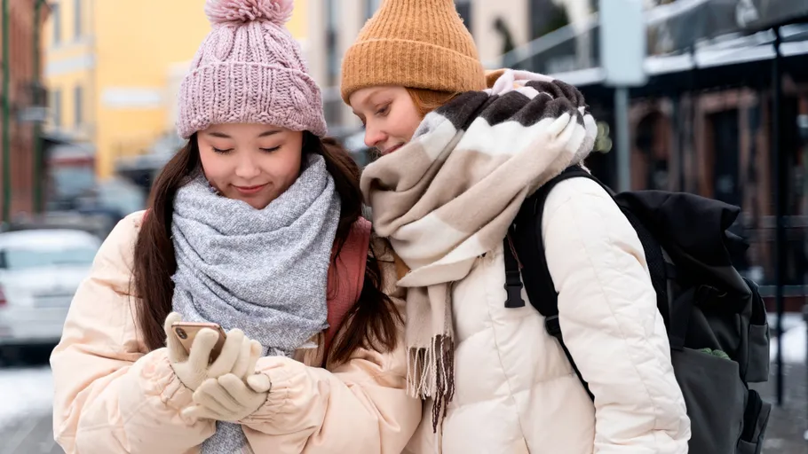 Zwei Frauen schauen aufs Handy, Winterstraße.
