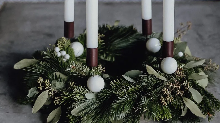Christmas wreath with candles on table.
