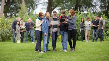 Menschen studieren Papiere im Park.