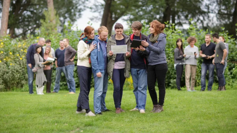 Menschen studieren Papiere im Park.