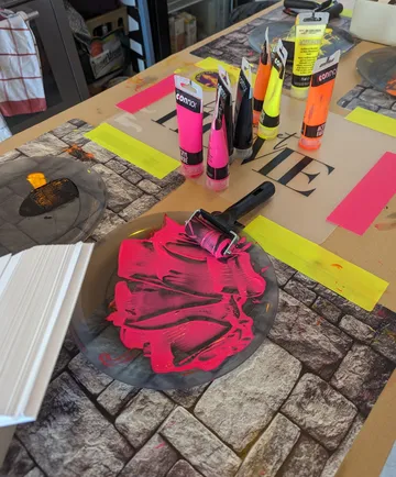 Paint tubes and roller on art table.