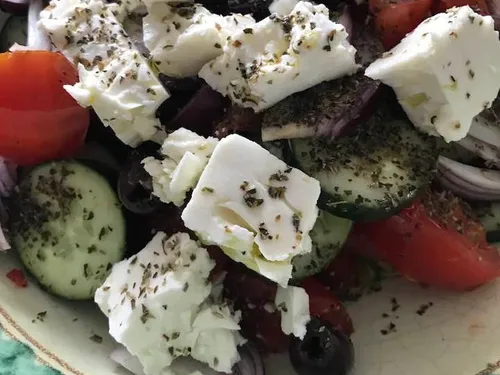 Griechischer Salat mit Feta, Gurke und Tomate in einer Schüssel.