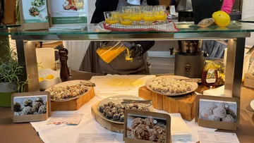 Person gießt Saft hinter Dessertauslage.