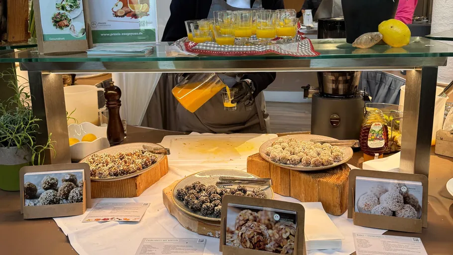 Person pours juice behind a dessert display.