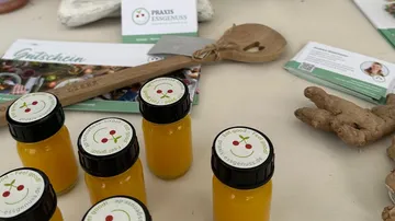 Gelbe Saftflaschen auf Tisch mit Ingwer.