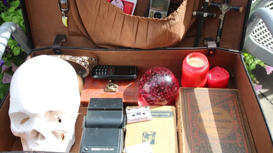 Open suitcase with various objects inside.