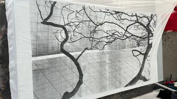 Black-and-white tree branches art on wall.