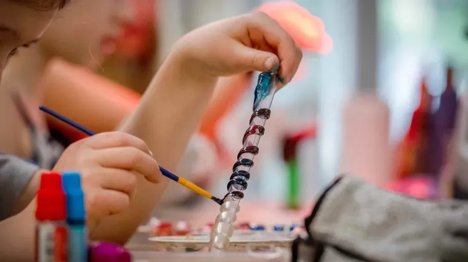 Child painting colorful spiral in art class.