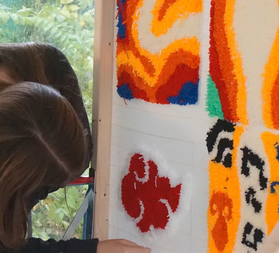 Person begutachtet bunte Teppichdesigns innen.