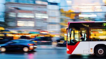 Bus und Auto auf belebter Straße.