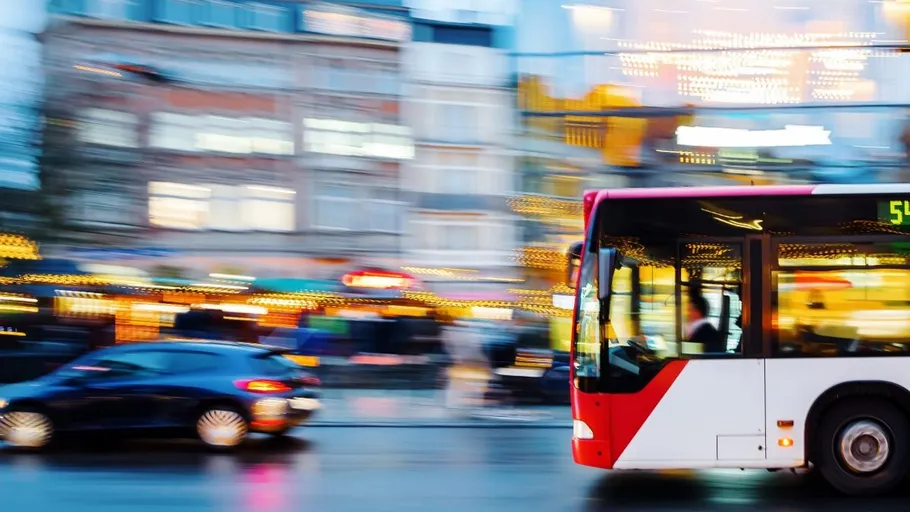 Bus und Auto auf belebter Straße.