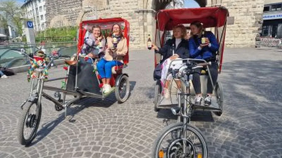 Two rickshaws with passengers on cobblestone street.