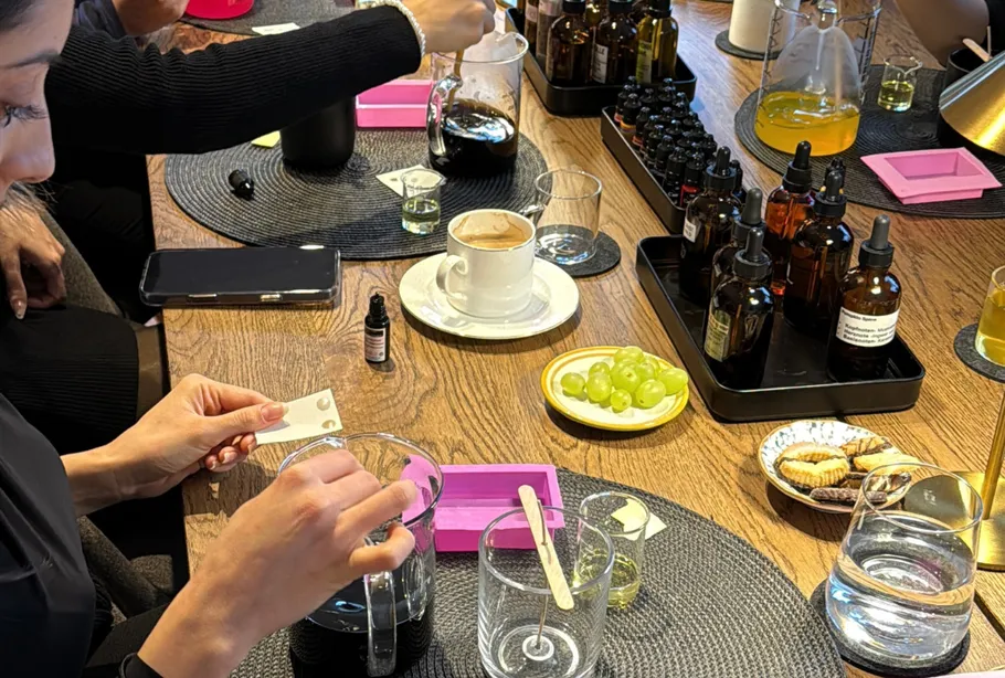 People creating perfumes at a workshop table.