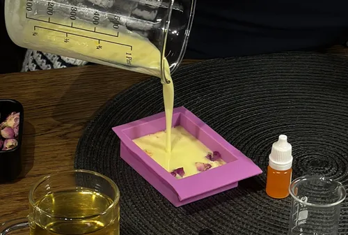 Liquid poured into pink mold on table.