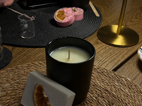 Black candle on wooden table with decor.