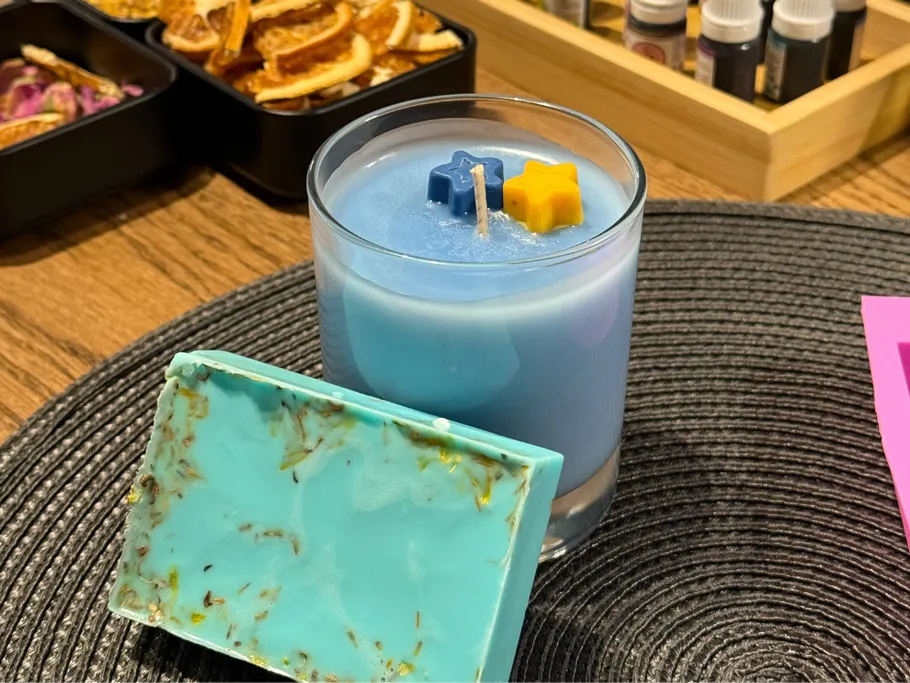 Blaue Kerze mit Stern-Dekorationen auf Tisch.