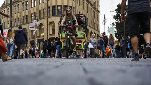 Person rides a pedicab in busy city street.