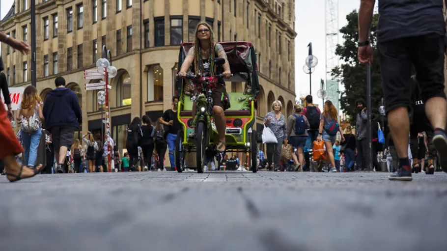 Person rides a pedicab in busy city street.