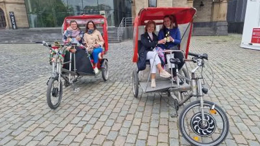 People sitting on pedicabs outdoors.